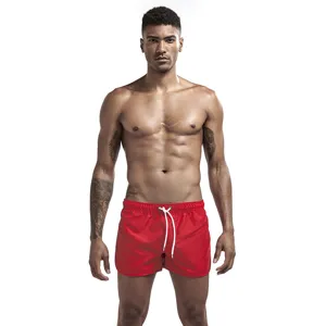 Pantaloncini da mare rossi da uomo con coulisse bianca. Costume da bagno estivo casual.