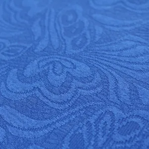 Blue jacquard fabric detail close-up showing intricate vintage woven patterns clearly.