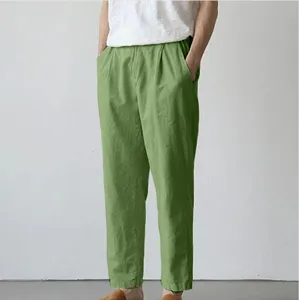 Detailed view of casual linen trousers in green, featuring relaxed fit and side pockets.