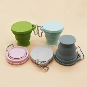 Closeup detail showing multi-color portable collapsible silicone cups with metal carabiners for travel.