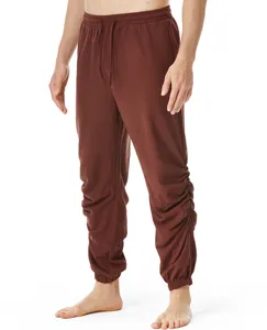 Vista detallada de pantalones casuales marrones para hombre de lino con cordón y cintura elástica.