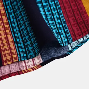 Dettaglio del tessuto della camicia etnica da uomo con motivo a righe e quadri colorati.