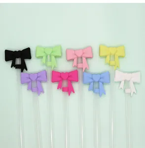 Close-up detail of colorful silicone bow straw toppers, cute heart straw covers for cups.