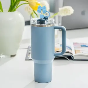 Blue stainless steel tumbler with handle and cute bow straw cover for daily hydration use.