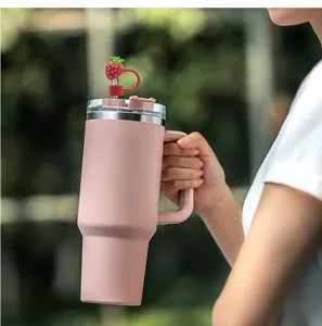 Rosa Thermosbecher mit praktischem Griff und süßem Erdbeer-Strohhalmdeckel für Getränke im Detail.