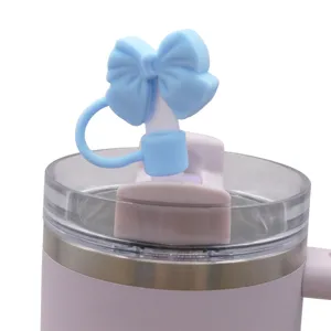 Pink tumbler cup featuring a cute blue bow silicone straw cover and dust plug, main front view.