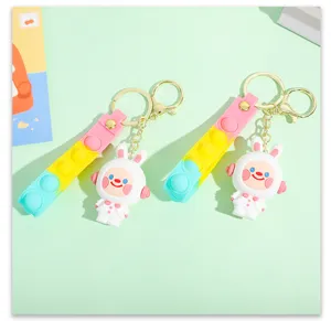 Detail shot of the cute cartoon space rabbit keychain with pop-it decompression strap and 3D doll.