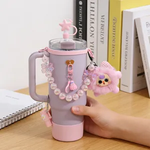 Gobelet isotherme rose avec lanière de chaîne en perles, couvercle de paille et pendentif en peluche.