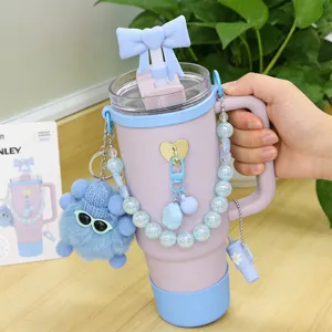 Vue détaillée des accessoires pour tasse Stanley avec chaîne perlée et pendentif peluche.