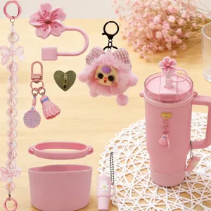Set d'accessoires tasse rose avec embout paille floral, botte silicone et jolis charms décoratifs.