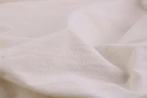 Detailed close-up view of breathable cotton linen fabric texture with natural soft folds.