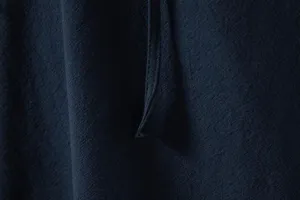 Close-up detail of men's cotton linen casual shirt fabric texture and fine stitching.