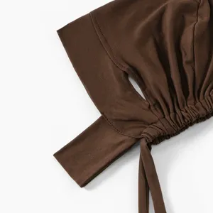 Détail de bonnet de chimio en coton mercerisé marron, trous pour oreilles et lanières.