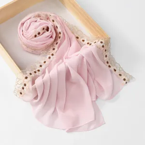 Pink chiffon scarf close-up featuring delicate brown floral lace trim and soft fabric texture.