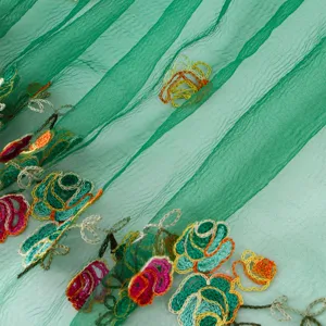 Detailed view of green polyester embroidered sheer long scarf fabric texture and floral design.