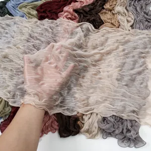 Crinkled solid color long scarf detail showing soft lightweight sheer fabric texture.