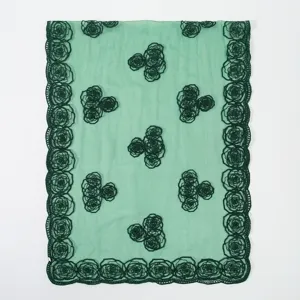 Close-up of exquisite dark green rose embroidery details on light green sheer summer scarf.