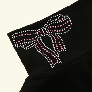 Dettaglio fiocco in strass su falso collo termico nero, elegante scaldacollo invernale.