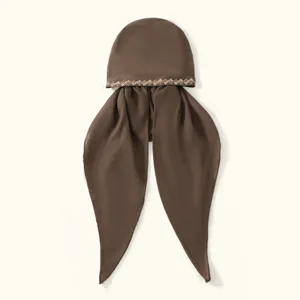 Gros plan sur le foulard marron en strass avec bande de cristal scintillante et tissu doux.