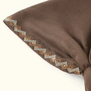Gros plan détail d'un bonnet turban marron pour femme avec élégants strass en zigzag.