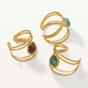 Detail of vintage gold-plated titanium steel open rings with colorful stones.