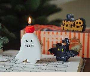 Detalle de cerca de velas aromáticas con forma de fantasma blanco y murciélago negro