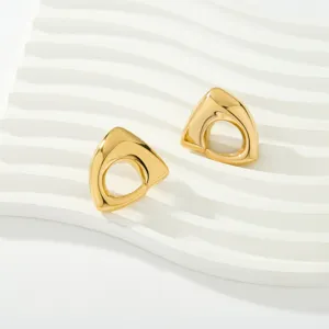 Primer plano de pendientes dorados irregulares calados con un diseño minimalista