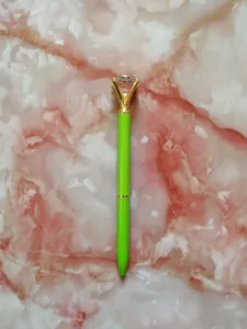 Macro view of a lime green ballpoint pen with a large crystal diamond topper