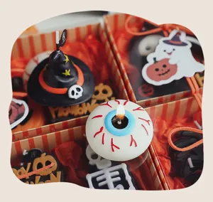 Detalle de velas perfumadas de Halloween con forma de ojo y sombrero de bruja en caja
