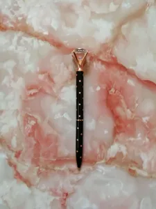 Macro detail of black polka dot ballpoint pen with a large crystal topper decorative