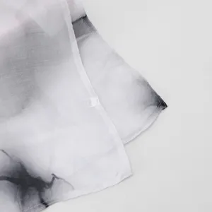 Close-up detail of gradient ink style women scarf showing fine edge stitching and voile texture.