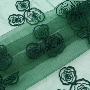 Detailed view of dark green sheer fabric scarf featuring delicate embroidered rose floral patterns.