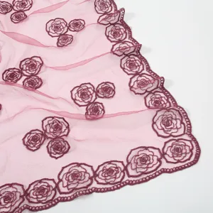 Close-up detail of sheer pink gauze scarf featuring elegant wine red floral embroidery.