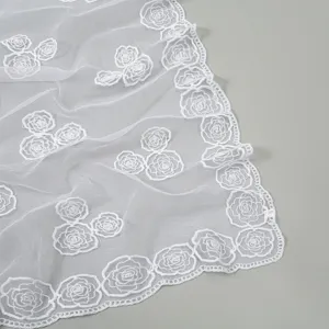 White sheer mesh scarf with delicate floral lace embroidery, elegant draped detail view.
