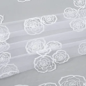 Detail shot of white mesh fabric featuring elegant embroidered rose patterns and fine texture.