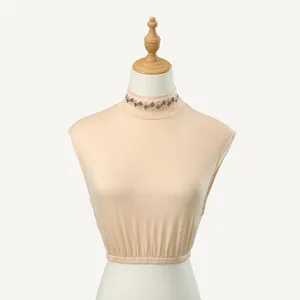 Detail view of the elegant beige mock neck fake collar with sparkling rhinestone rhombus pattern.