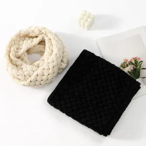Detailansicht des dicken, gestrickten Winterschal-Neckwarmers in Beige und Schwarz.