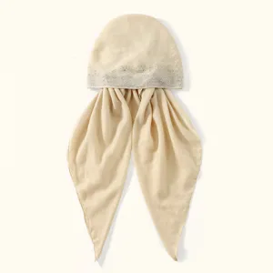 Details of the beige rhinestone turban hat, featuring delicate hot-drill details and soft fabric.