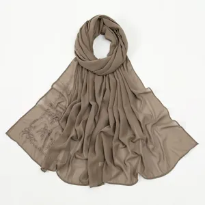 Close-up detail of the elegant chiffon hijab scarf featuring delicate bow embroidery accents.