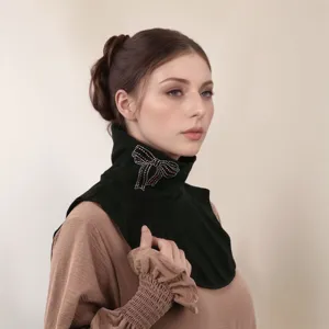 Primo piano del finto collo in velluto nero con fiocco in strass, scaldacollo.