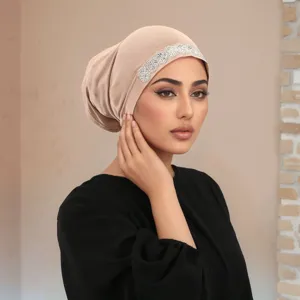 Close-up of a women beige rhinestone hijab cap, elegant polyester soft base turban style.
