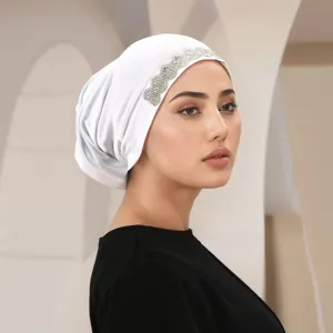 Detailed close-up of a white women's rhinestone embellished headscarf hat, elegant design.
