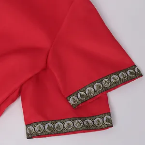 Close up detail of medieval costume sleeve with gold woven trim, red fabric.