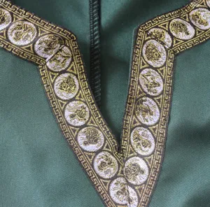 Medieval men's costume shirt detail showing exquisite gold and white V-neck trim design.