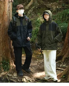 Outdoor couple functional windbreaker jacket detail view showing forest scene and practical design.