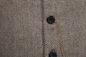 Detailaufnahme der braunen Herren Fischgrät Tweed Anzugweste mit dekorativer Kette.