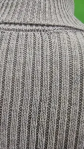 Tessuto maglione in maglia a coste grigio primo piano dettaglio texture filato lana.
