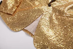 Gros plan sur les détails d'un blazer homme à sequins dorés et beau col brillant.
