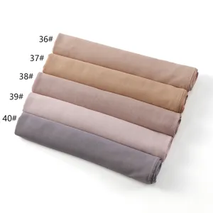 Gedetailleerd overzicht van effen modalsjaals netjes opgerold, met verschillende kleuren.