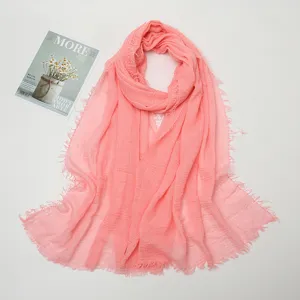 Close-up details of the pink cotton linen crinkled scarf with stylish frayed fringe edges.